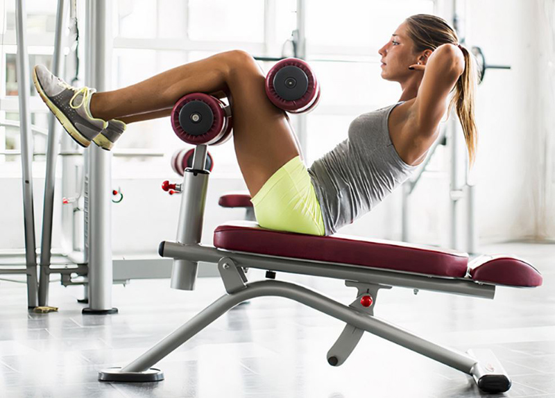 Thực hiện bài tập gập bụng trên ghế tạ đa năng